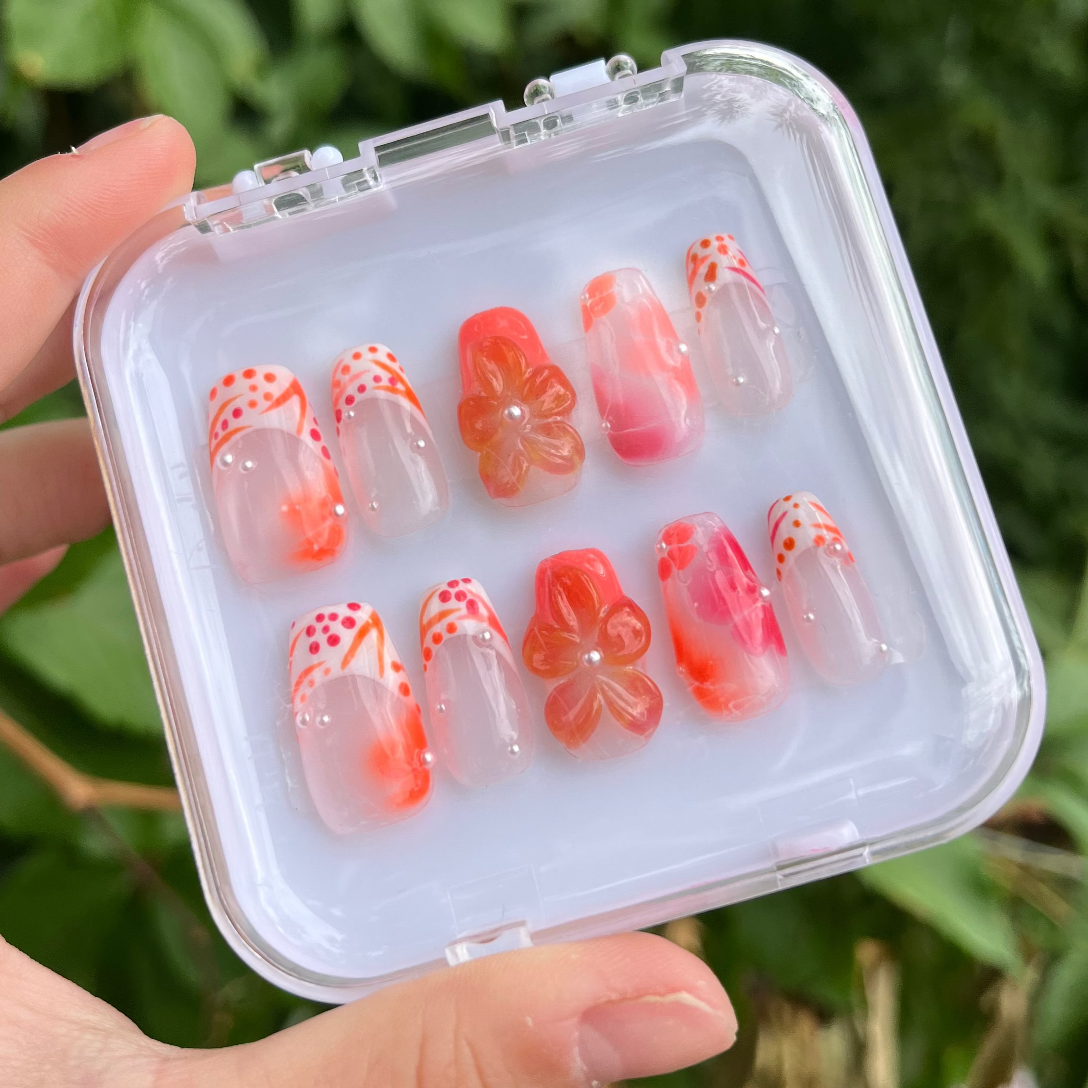Set of orange vibes press-on nails with white custom french tip. 3d flower and clear custom nail.