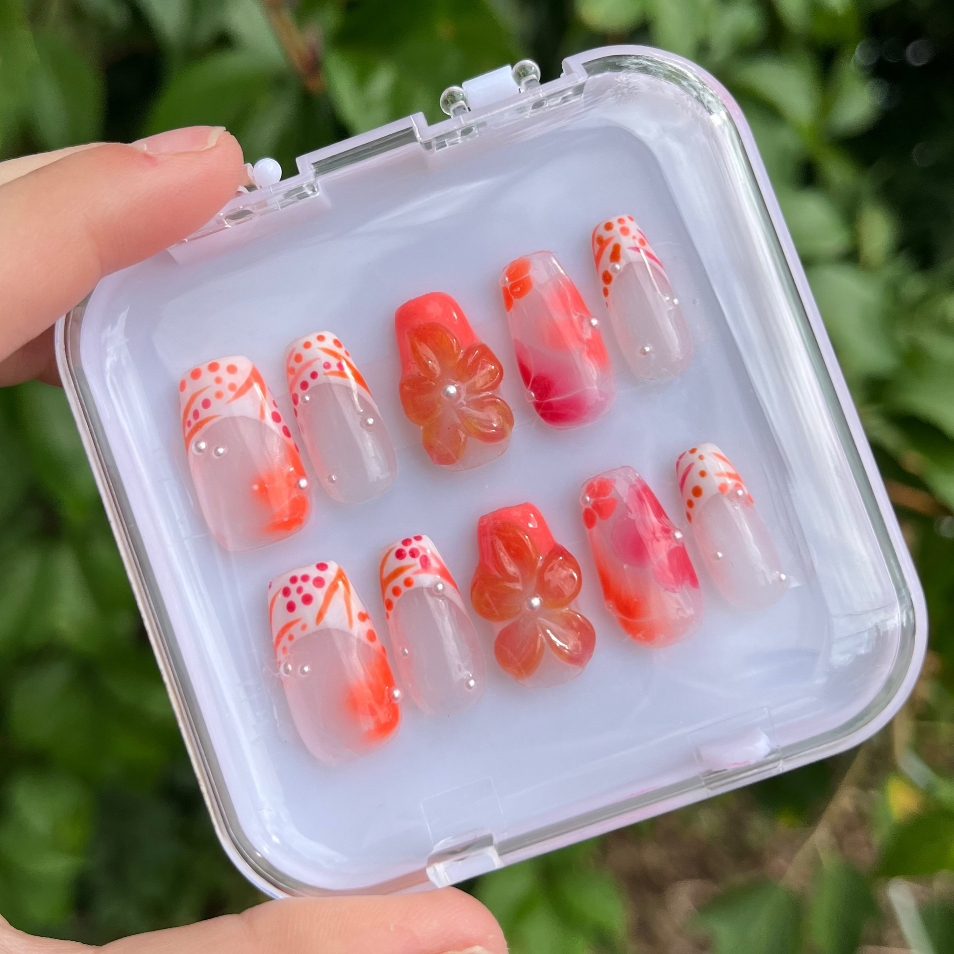Set of orange vibes press-on nails with white custom french tip. 3d flower and clear custom nail.